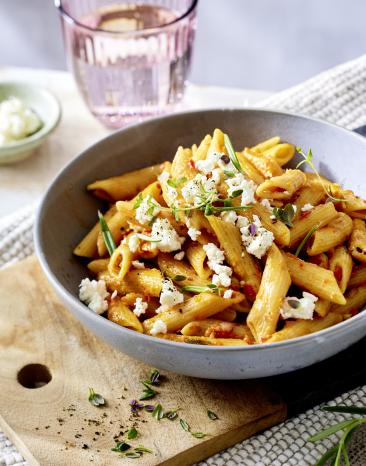 One-Pot Pasta mit Gemüsepesto mit einem Glas Wasser.